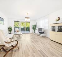 Na predaj 4-izb. rodinný dom s garážou, Kútniky - Svetlá obývačka s podlahou s dreveným dekorom, sedačka, kreslo a televízor.