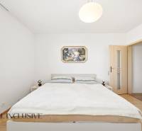 Na predaj 4-izb. rodinný dom s garážou, Kútniky - Spálňa v rodinnom dome s jednoduchým nábytkom a podlahou s dreveným dekorom.