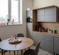 Prenájom klimatizovaná kancelária: 25 m2 a 42 m2 - Trnava Chovateľská - Kuchynský kút v kanceláriách s oknom, dreveným dekorom a jedálenským stolom.