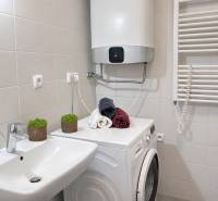 NOVOSTAVBA (2019) + PARKOVANIE | 2-izbový byt 69 m² – Bratislava - Kúpeľňa s práčkou v 2-izbovom byte, bielymi obkladmi a uterákmi.