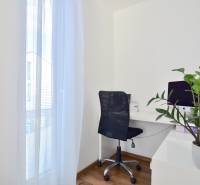 UHLISKÁ, 3-i byt, 80 m2 – zariadená novostavba s parkovaním v cene - Pracovný kút s počítačom, čiernou stoličkou a rastlinou na podlahe s dreveným dekorom.