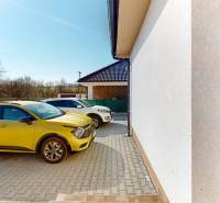 4-IZBOVÁ NOVOSTAVBA Horné Štitáre - Žlté auto zaparkované pri rodinnom dome v Horných Štitároch, slnečný deň, dlažba.