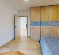 4-IZBOVÁ NOVOSTAVBA Horné Štitáre - Spálňa s posuvnou skriňou a podlahou s dreveným dekorom v Rodinnom dome.