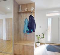 4-IZBOVÁ NOVOSTAVBA Horné Štitáre - Interiér rodinného domu s podlahou s dreveným dekorom a zrkadlovou skriňou pri dverách.