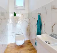 4-IZBOVÁ NOVOSTAVBA Horné Štitáre - Kúpeľňa v rodinnom dome s podlahou s dreveným dekorom a mramorovým obkladom stien.