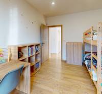 4-IZBOVÁ NOVOSTAVBA Horné Štitáre - Detská izba v rodinnom dome s podlahou s dreveným dekorom, poschodovou posteľou a písacím stolom.