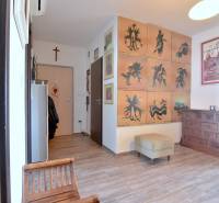 PRI VINOHRADOCH, 3-i byt s veľkými loggiami, 113 m2, RAČANY BIANCO - Chodba v 3-izbovom byte s kreslami, obrazmi a podlahou s dreveným dekorom.