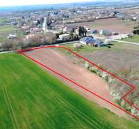 Ondrejovce – 4.665 m2 POZEMOK na rekreačnú chatu na hranici obce - Letecký pohľad na poľnohospodársku plochu v Ondrejovciach obklopenú záhradami a dedinou.