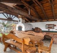 I Predaj štýlového tehlového domu v Rajke pri Bratislave - Drevený altánok s pecou a dreveným nábytkom pri rodinnom dome v Rajke na Jókai Mór ulici.