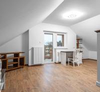 I Predaj štýlového tehlového domu v Rajke pri Bratislave - Podkrovná miestnosť v rodinnom dome s pracovným stolom a podlahou s dreveným dekorom.