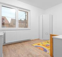 I Predaj štýlového tehlového domu v Rajke pri Bratislave - Detská izba s bielym nábytkom a podlahou s dreveným dekorom v rodinnom dome.