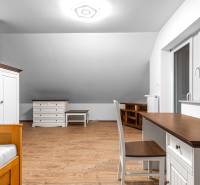 I Predaj štýlového tehlového domu v Rajke pri Bratislave - Izba s podlahou s dreveným dekorom, pracovným stolom a skriňou v rodinnom dome.