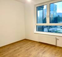 I Predaj 3i bytu v novostavbe v Rači - Izba v 3-izbovom byte s podlahou s dreveným dekorom a veľkým oknom.