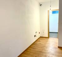 I Predaj 3i bytu v novostavbe v Rači - Prázdna miestnosť s podlahou s dreveným dekorom v 3-izbovom byte.