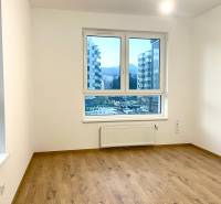 I Predaj 3i bytu v novostavbe v Rači - Izba s bielymi stenami a podlahou s dreveným dekorom v 3-izbovom byte.