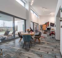 I PREDAJ moderná vila s bazénom a veľkým pozemkom - Interiér Vily s podlahou s dreveným dekorom, jedálenským stolom a posedením pre hostí.