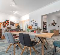 I PREDAJ moderná vila s bazénom a veľkým pozemkom - Interiér vily s podlahou s dreveným dekorom, závesmi a dreveným stolom, zdobené stoličky.