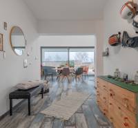 I PREDAJ moderná vila s bazénom a veľkým pozemkom - Chodba vo vile s dekorovanými stenami, podlaha s dreveným dekorom, zrkadlo, nábytok a výhľad.