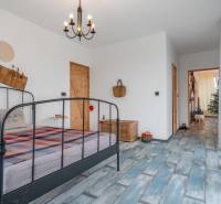 I PREDAJ moderná vila s bazénom a veľkým pozemkom - Spálňa vo vile so vzorovanou prikrývkou, lustrom a dekoratívnymi predmetmi na stene.