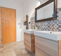 I PREDAJ moderná vila s bazénom a veľkým pozemkom - Kúpeľňa vo Vile so vzorovanými obkladačkami, dvojumývadlom a drevenými dverami.