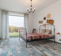 I PREDAJ moderná vila s bazénom a veľkým pozemkom - Minimalistická spálňa vo vile s kovovou posteľou, farebným prehozom a dekoráciami.