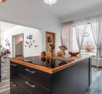 I PREDAJ moderná vila s bazénom a veľkým pozemkom - Moderná kuchyňa vo vile s podlahou s dreveným dekorom, závesmi a dekoráciami.