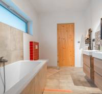 I PREDAJ moderná vila s bazénom a veľkým pozemkom - Kúpeľňa vo vile s podlahou s dreveným dekorom, vaňou a farebnými obkladmi.