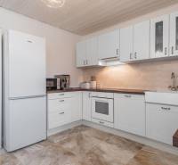 Stavebný pozemok 8 500 m² s podnikateľským potenciálom - Svetlá kuchyňa s bielymi skrinkami a poličkami, podlaha s dreveným dekorom.
