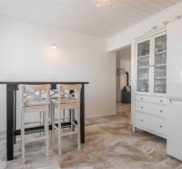 Stavebný pozemok 8 500 m² s podnikateľským potenciálom - Interiér s jedálenským stolom a stoličkami, vedľa biely kuchynský nábytok.