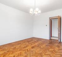 I Na predaj dvojposchodový 5i rodinný dom pri Žiline - Priestranná izba s podlahou s dreveným dekorom, lustrom a otvorenými dverami v rodinnom dome.