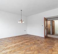 I Na predaj dvojposchodový 5i rodinný dom pri Žiline - Interiér rodinného domu s podlahou s dreveným dekorom a závesným osvetlením.