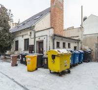 I Predaj komerčného priestoru na ul. Obchodná - Pohľad na zasnežené nádvorie s kontajnermi a staršou budovou v Bratislave - Starom Meste.