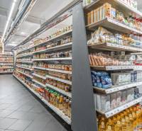 I Predaj komerčného priestoru na ul. Obchodná - Regály s potravinami v obchodných priestoroch, rôzne produkty a dochucovadlá na pultoch.