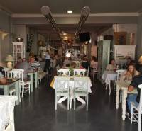 I Predaj komerčného priestoru na ul. Obchodná - Interiér obchodných priestorov s návštevníkmi pri stoloch a dekoráciami v retro štýle.