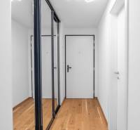 : Nadštandardný 2-i byt v projekte ZWIRN za cenu „štandardu“ - Chodba v 2-izbovom byte s drevenou podlahou a bielymi stenami.