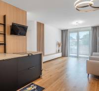 : Nadštandardný 2-i byt v projekte ZWIRN za cenu „štandardu“ - Obývacia izba v 2-izbovom byte s drevenou podlahou a vstavanou kuchyňou.