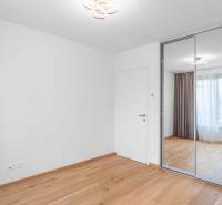 : Nadštandardný 2-i byt v projekte ZWIRN za cenu „štandardu“ - Prázdna miestnosť so vstavanou skriňou, drevenou podlahou a veľkým oknom v 2-izbovom byte.