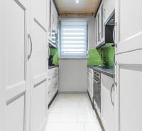 I Na predaj 2-i byt s terasou v Auersthal (Rakúsko) - Kuchyňa v 2-izbovom byte s bielymi skrinkami, zeleným obkladom a svetlou podlahou.