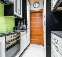 I Na predaj 2-i byt s terasou v Auersthal (Rakúsko) - Úzka kuchyňa s bielymi skrinkami, čiernymi pracovnými doskami a zelenými obkladačkami v 2-izbovom byte.