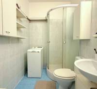 - PRENÁJOM - 1 IZBOVÝ BYT - TOPOĽČIANSKA UL. - PETRŽALKA - Kúpeľňa v 1-izbovom byte s práčkou, sprchovacím kútom a bielymi skrinkami.