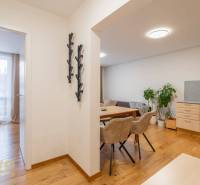 Exkluzívny byt v srdci Vysokých Tatier na Štrbskom Plese - Interiér Rekreačného apartmánu s podlahou s dreveným dekorom, jedálňou a spálňou.