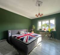 EXKLUZÍVNE - Útulný 3-izbový dom v Čiernom Brode s veľkým pozemkom - Spálňa v rodinnom dome s posteľou, zelenými stenami a podlahou s dreveným dekorom.