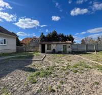 EXKLUZÍVNE - Útulný 3-izbový dom v Čiernom Brode s veľkým pozemkom - Záhrada pri rodinnom dome na ulici Heď v Čiernom Brode s nízkymi stavbami a plotom.