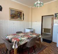 EXKLUZÍVNE - Útulný 3-izbový dom v Čiernom Brode s veľkým pozemkom - Kuchyňa v rodinnom dome s kvetinovým obrusom, stoličkami a podlahou s dreveným dekorom.