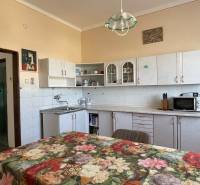 EXKLUZÍVNE - Útulný 3-izbový dom v Čiernom Brode s veľkým pozemkom - Kuchyňa v rodinnom dome s kvetinovým obrusom, bielymi skrinkami a farebnými stenami.