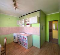 Priestranný 2-izbový byt s potenciálom zmeny dispozície- Šaca - Kuchyňa v 2-izbovom byte s podlahou s dreveným dekorom a zelenými stenami.