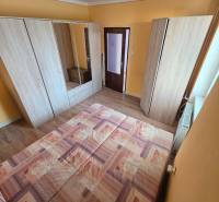 Priestranný 2-izbový byt s potenciálom zmeny dispozície- Šaca - Spálňa v 2-izbovom byte s podlahou s dreveným dekorom a žltými stenami.