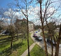 Priestranný 2-izbový byt s potenciálom zmeny dispozície- Šaca - Košice - mestská časť Šaca, Železiarenská, pohľad na stromy, chodník a zaparkované autá.