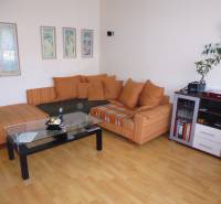 PRENÁJOM: M.NEŠPORA - 2-izbový byt, 58 m2, 7.posch. - Sídlisko III. - Obývacia izba v 2-izbovom byte so sedačkou a stolíkom na podlahe s dreveným dekorom.