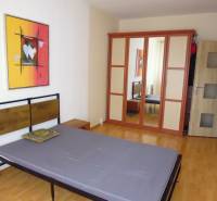 PRENÁJOM: M.NEŠPORA - 2-izbový byt, 58 m2, 7.posch. - Sídlisko III. - Spálňa s posteľou, podlahou s dreveným dekorom a skriňou v 2-izbovom byte.